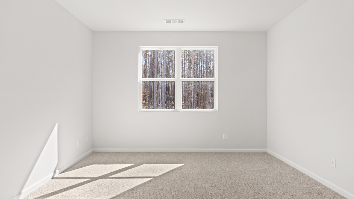 The bedroom has neutral carpet and a double window.