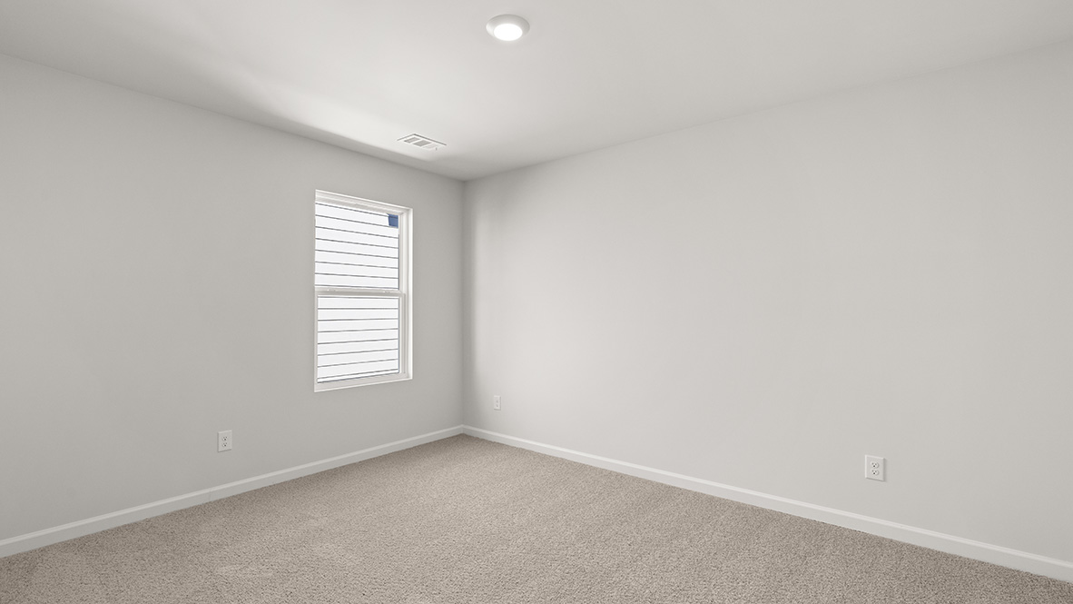 Bedroom with neutral carpet and a single window.