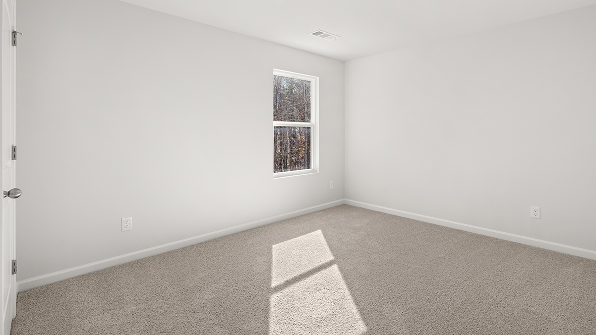 Bedroom with neutral carpet and a single window.