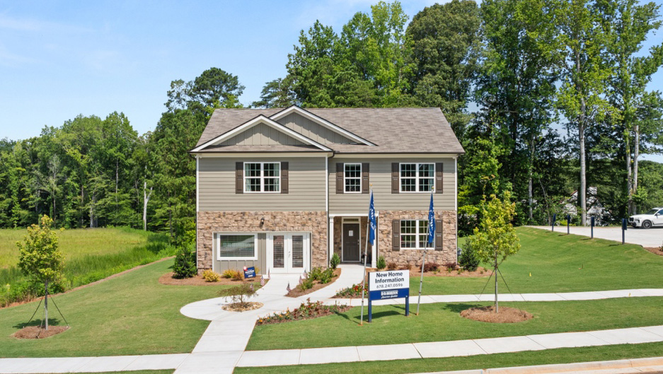front exterior of a two story model home with light brown siding and stone accents