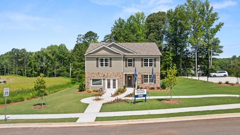 front exterior of a two story model home with light brown siding and stone accents