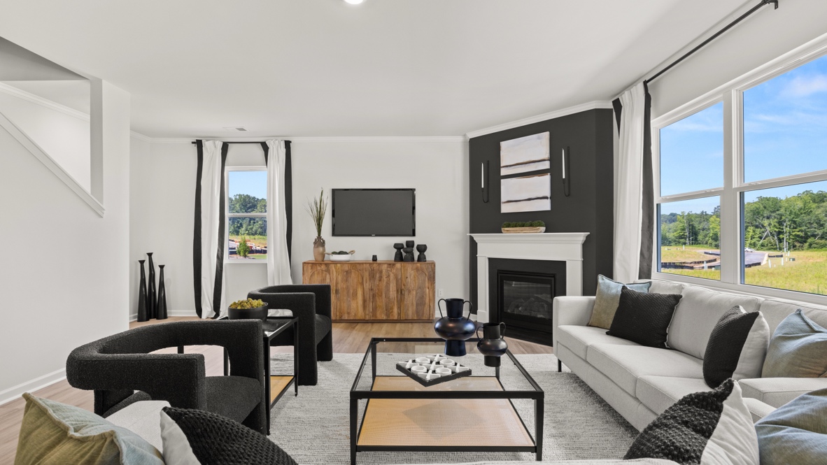 Spacious living room with brown flooring, white walls and windows