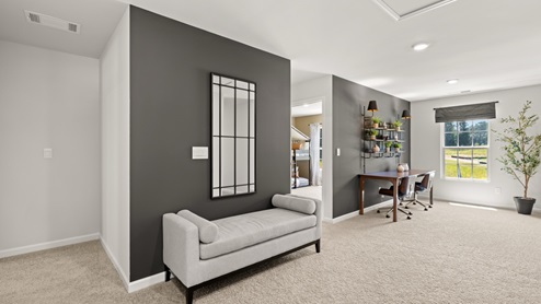 upstairs flex area with white walls, beige carpet and a window