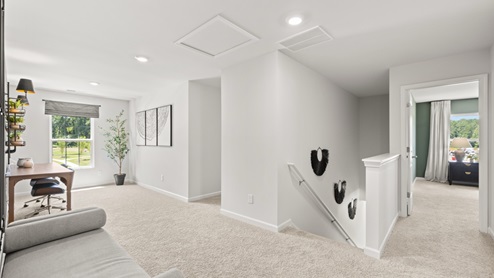 upstairs flex area with white walls, beige carpet and a window