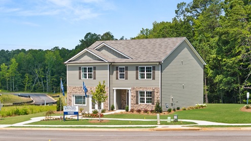 front exterior of a two story model home with light brown siding and stone accents