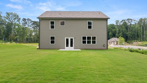 rear exterior of home featuring a spacious backyard
