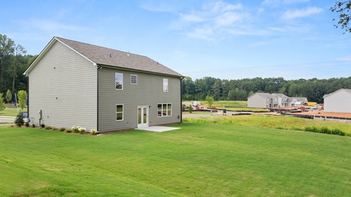 rear exterior of home featuring a spacious backyard