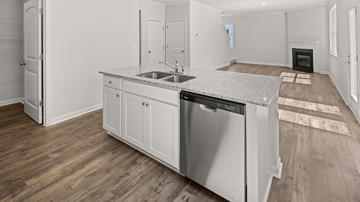 View of the living room with a fireplace from the kitchen.