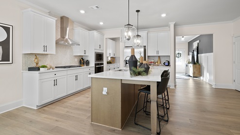 Butner Estates community model home kitchen with white cabinets with hardware and crown molding