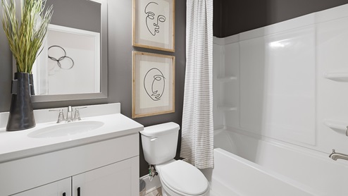 Bathroom with single sink vanity and step in bathtub.