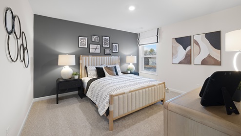 Bedroom with carpeted floors and window for natural lighting.