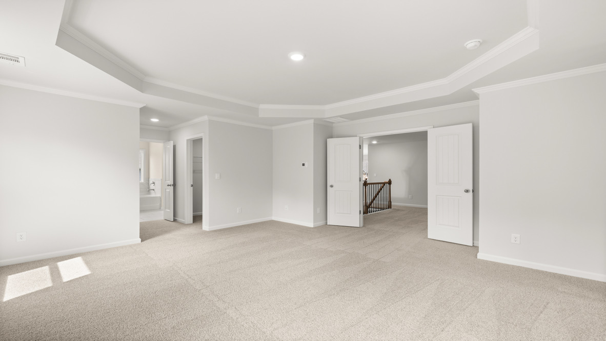 Interior primary bedroom with windows and bathroom