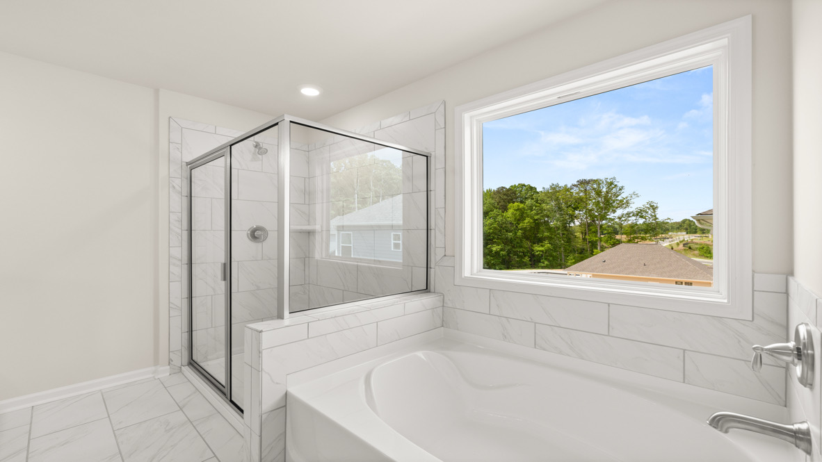 Interior primary bathroom with shower and bath tub