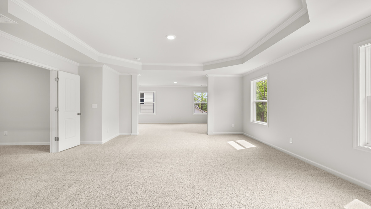 Loft + secondary bedroom with soft carpet and wide hallway entrance of Butner Estate, Grayson Plan