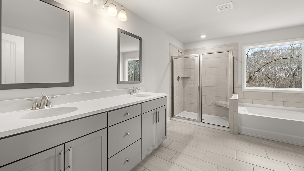 Interior primary bathroom with double sink, shower and bath tub