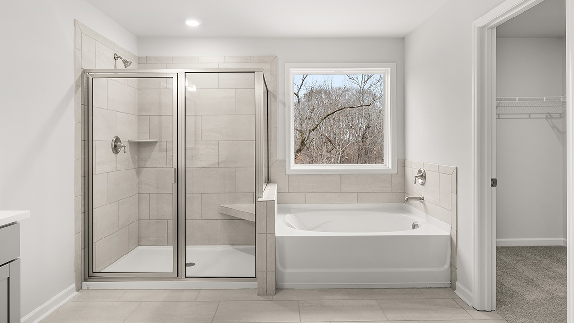 Interior primary bathroom with double sink, shower and bath tub