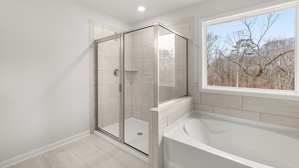 Interior primary bathroom with shower and bath tub