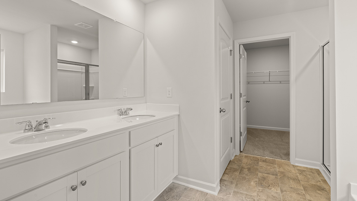 Interior primary bathroom with double sink and closet