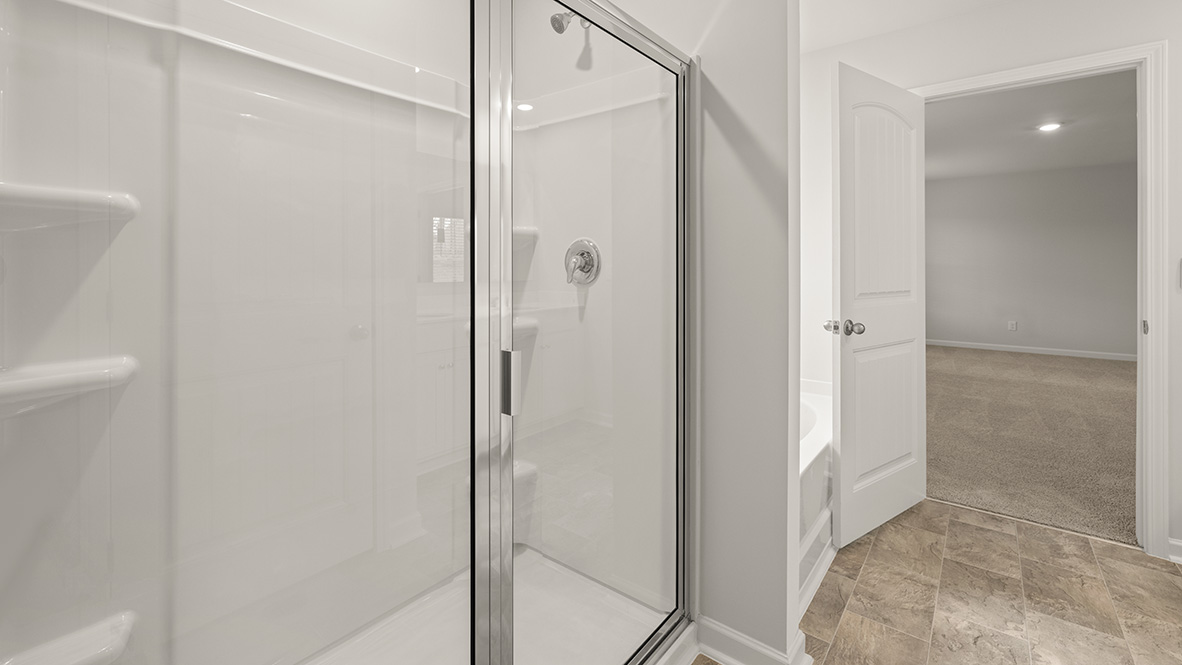 Interior primary bathroom with shower and walk-in closet