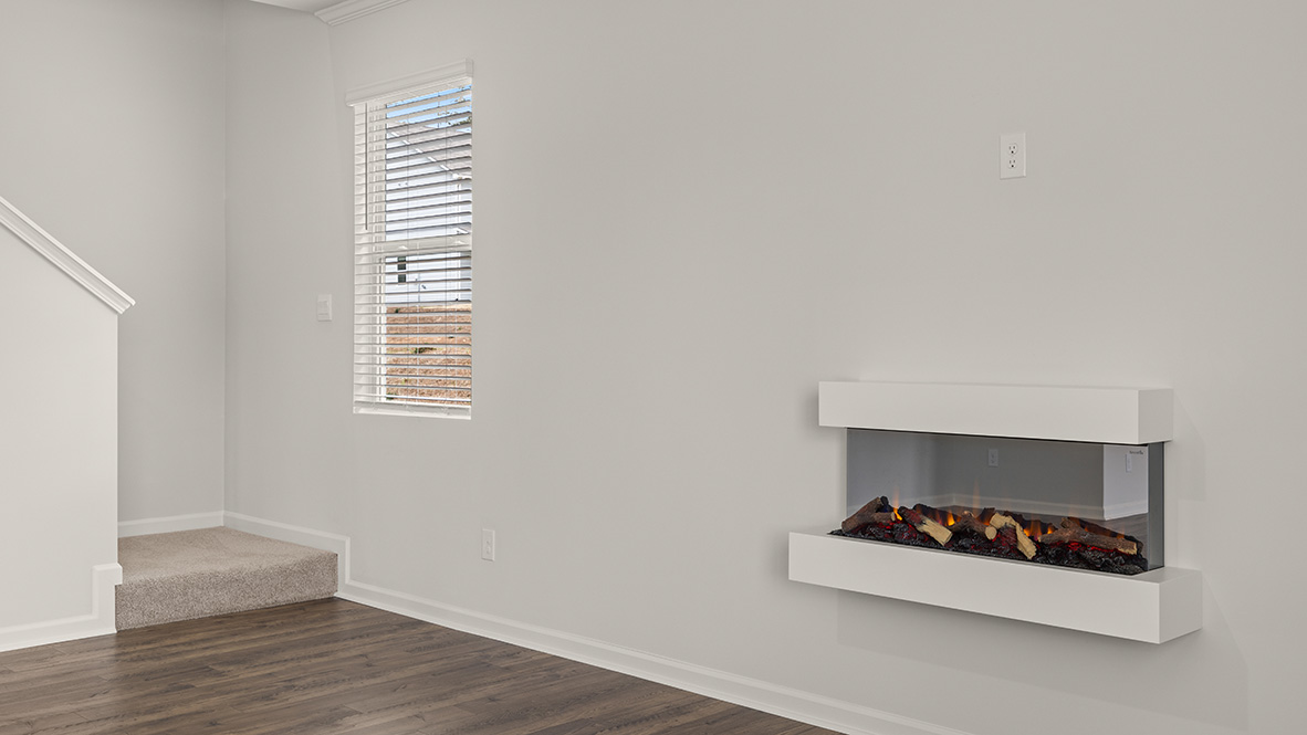 hanover living room with floating electric fireplace and stairway leading to the second floor at Thompson Ridge