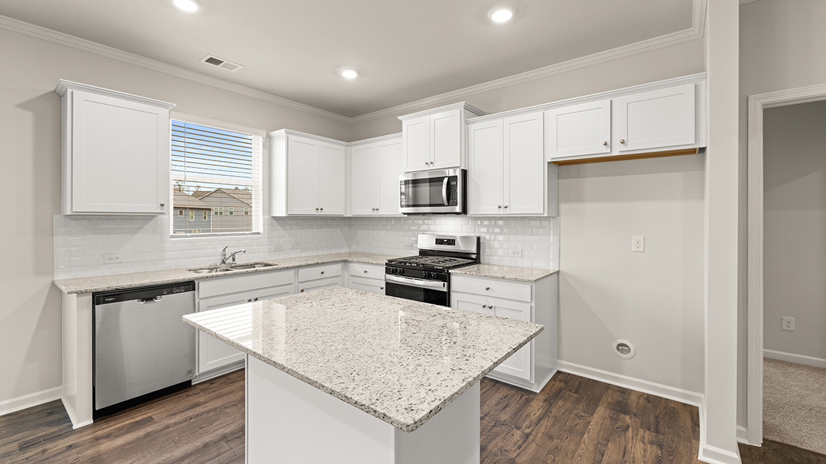 mansfield kitchen with white cabinets that opens to living room at thompson ridge in dallas georgia
