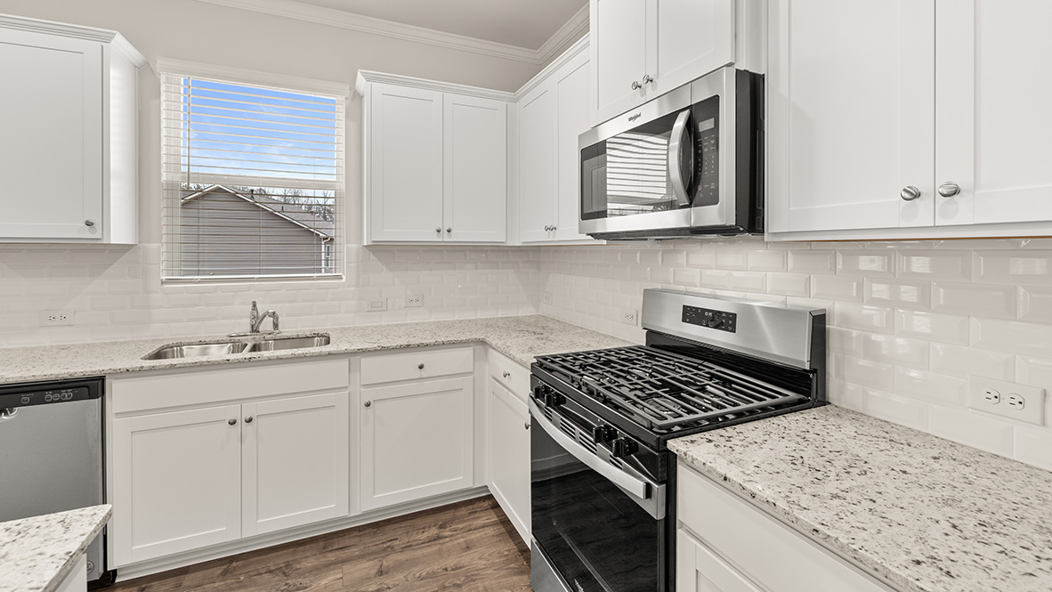 mansfield kitchen with white cabinets that opens to living room at thompson ridge in dallas georgia