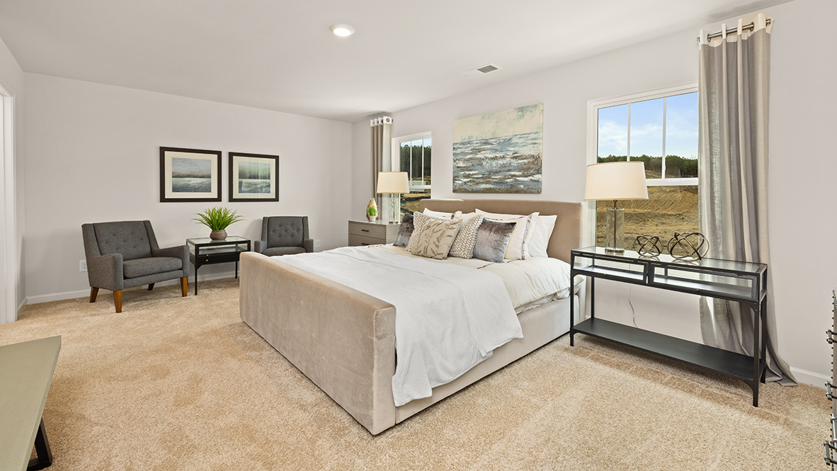 Interior primary bedroom with large windows