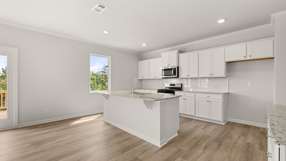 Interior kitchen with center island and white cabinets
