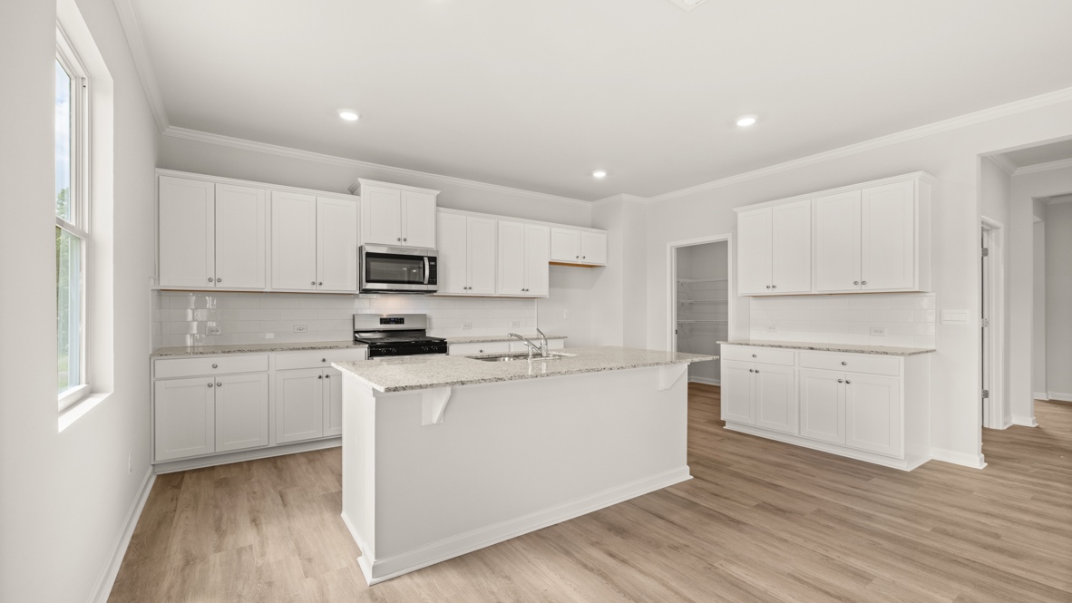 Interior kitchen with center island and white cabinets