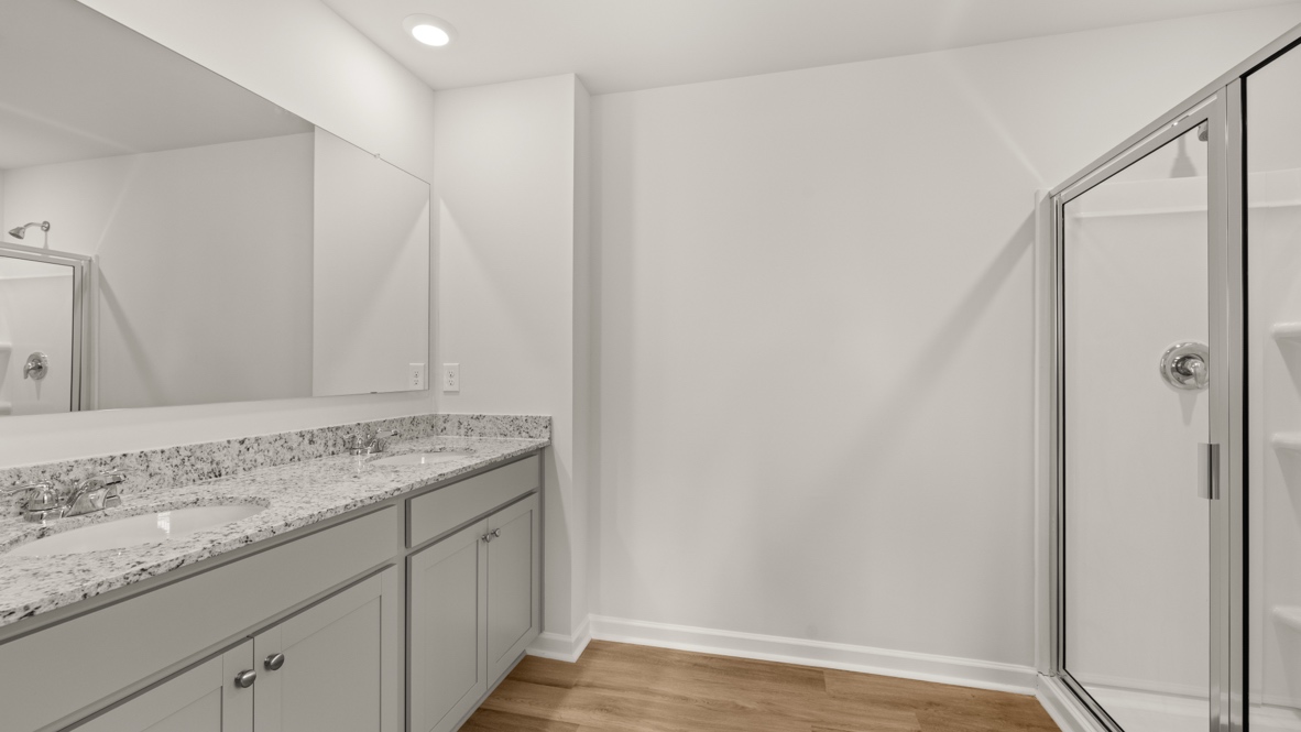 Interior primary bathroom with shower and double sink