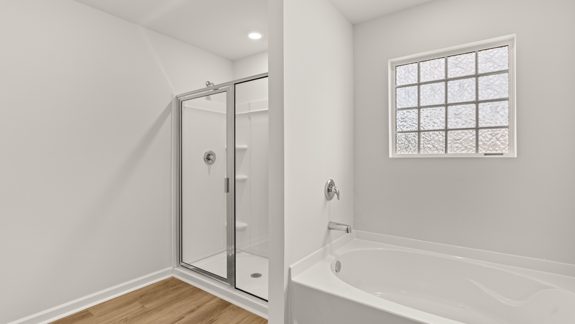 Interior primary bathroom with shower and bath tub