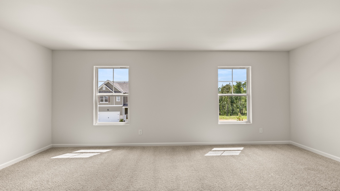 Interior primary bedroom with large windows