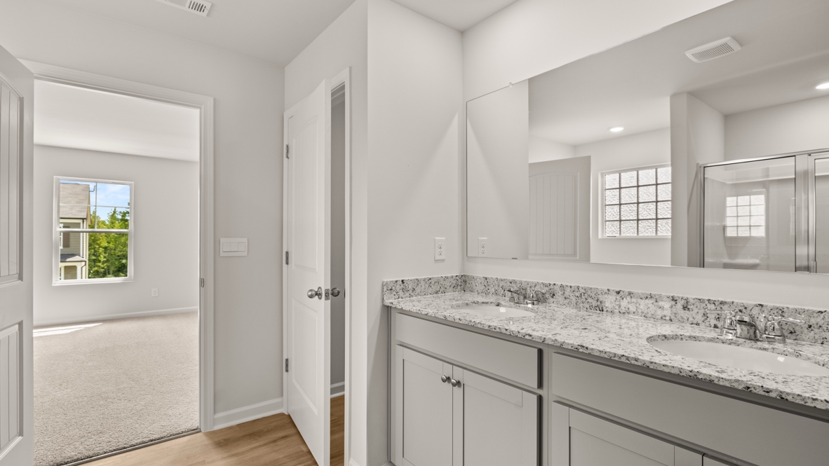 Interior primary bathroom with double sink and shower