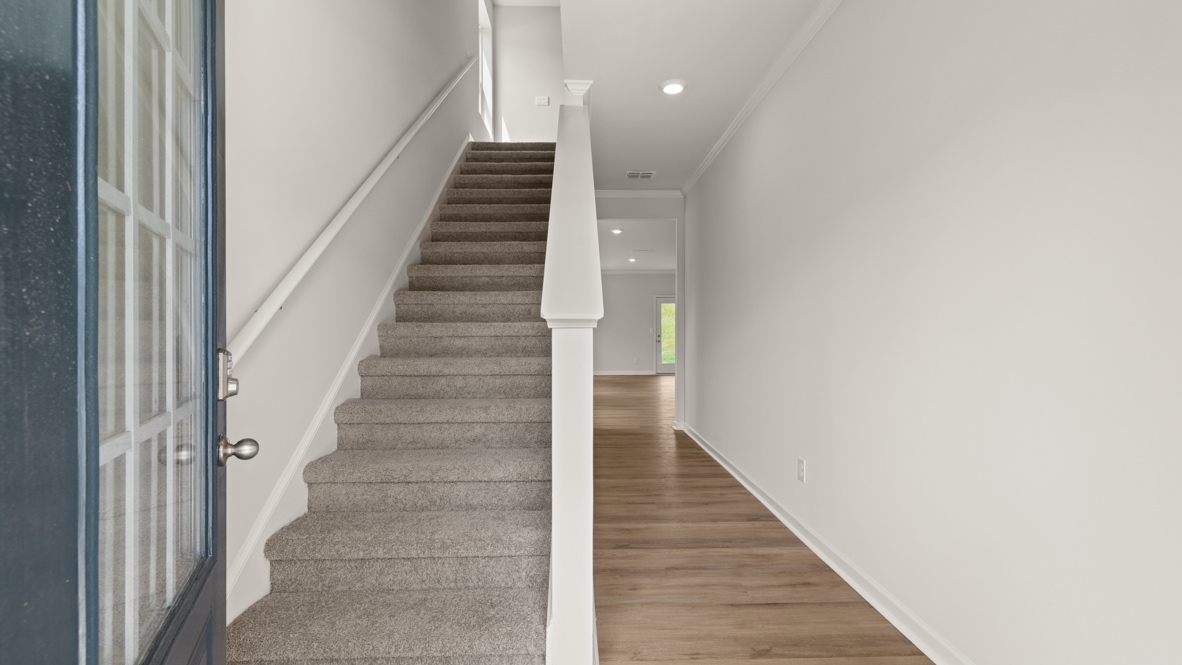 Interior entry-way open to staircase and leading to living area