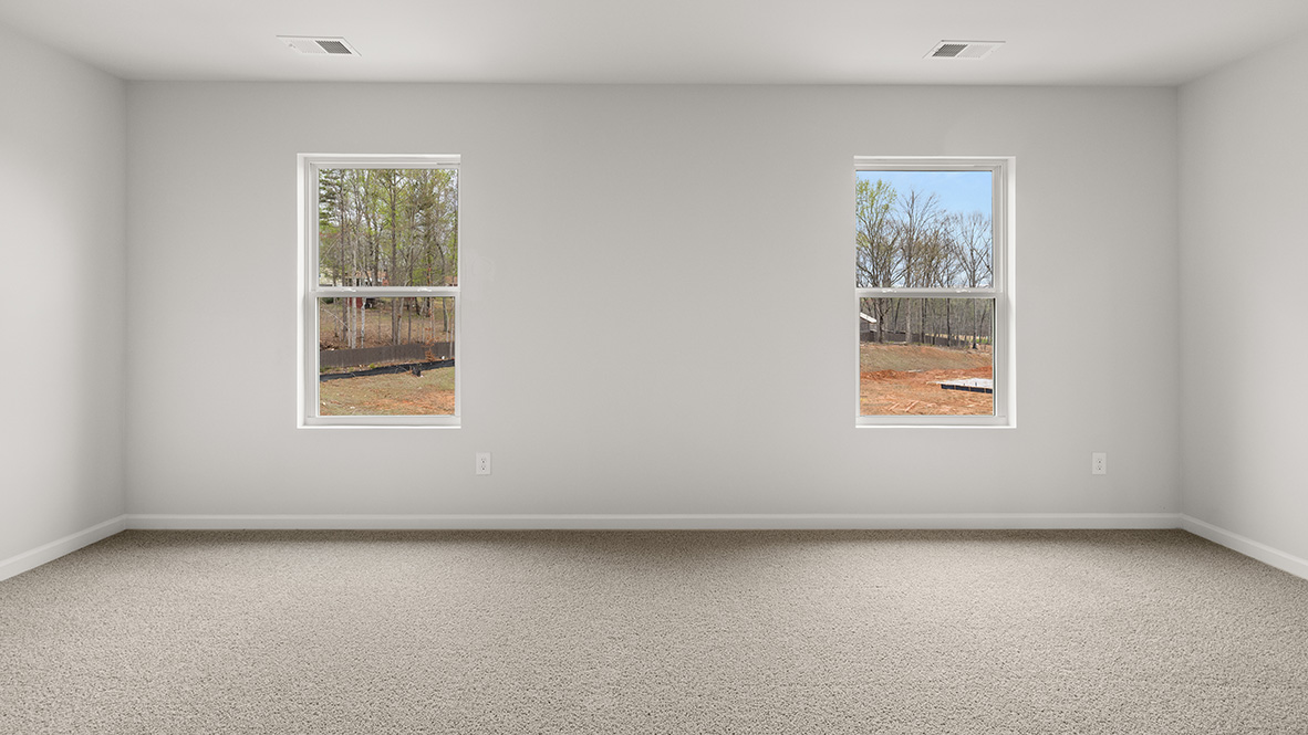 Interior primary bedroom with large windows