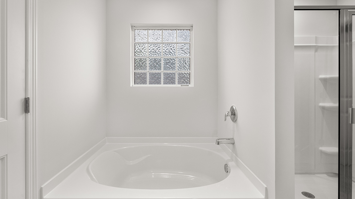 Interior primary bathroom with bath tub and shower
