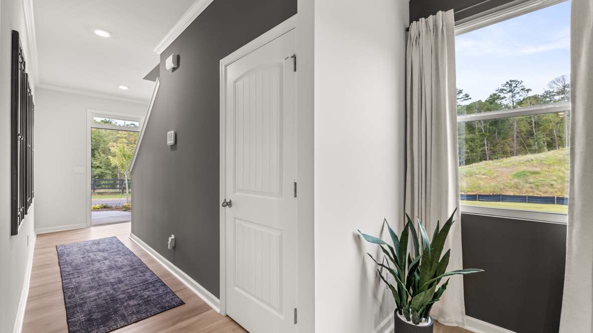 Interior entry-way open to staircase and leading to living area