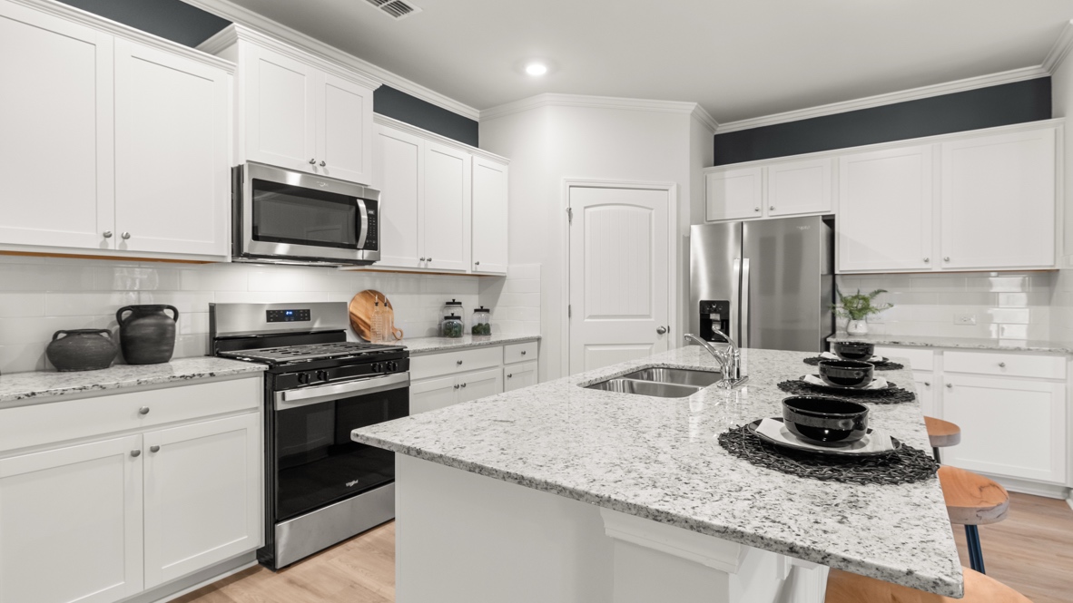 Interior kitchen with center island and white cabinets