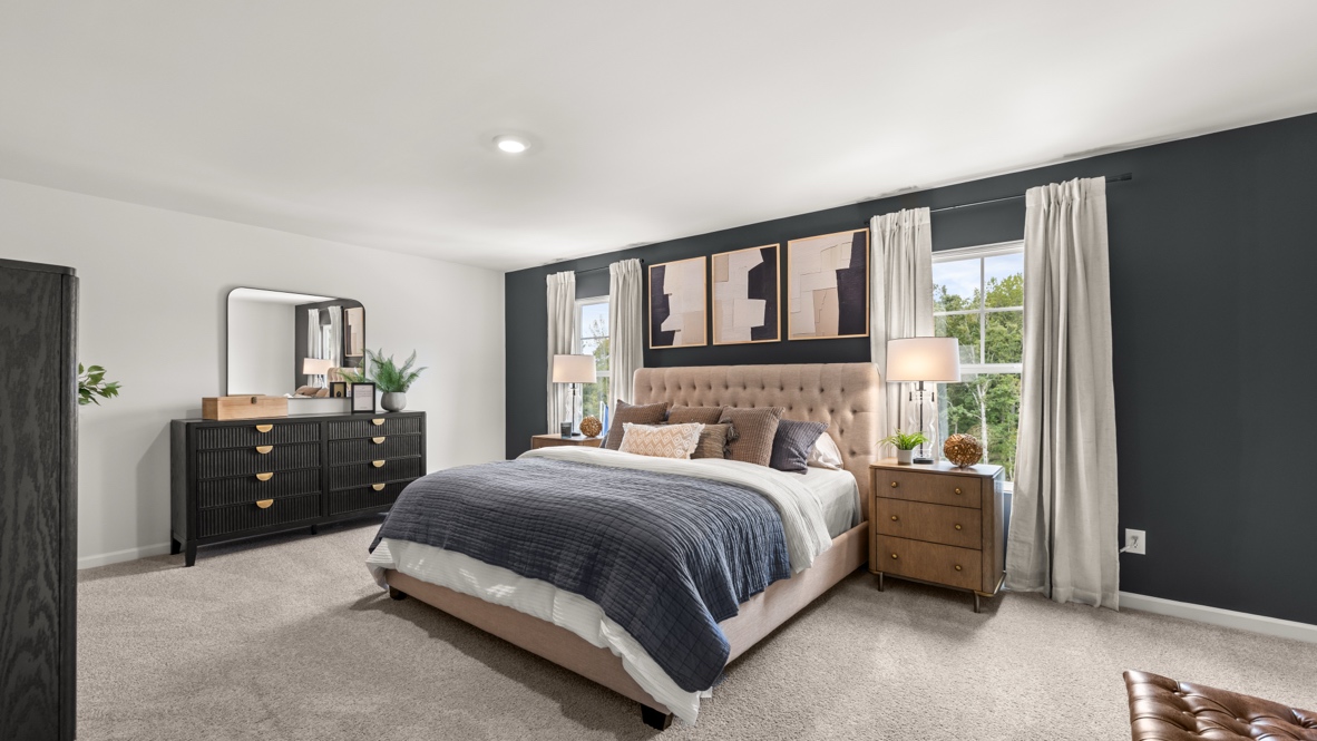 Interior primary bedroom with large windows and accent wall