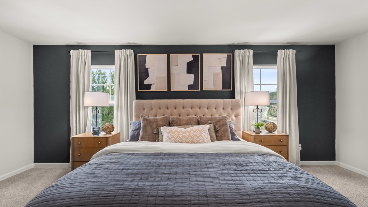 Interior primary bedroom with large windows and accent wall