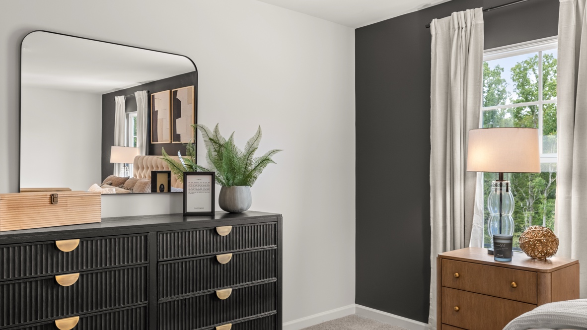 Interior primary bedroom with large windows and accent wall