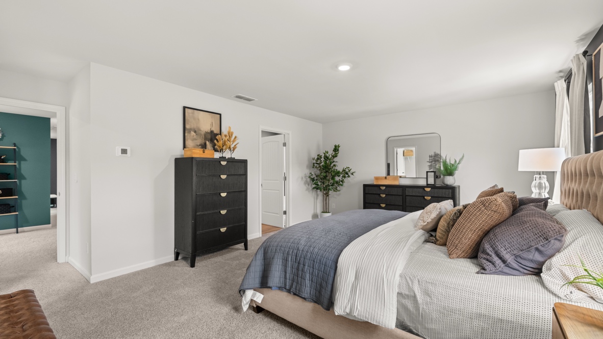 Interior primary bedroom with large windows and accent wall