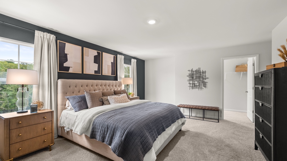 Interior primary bedroom with large windows and accent wall