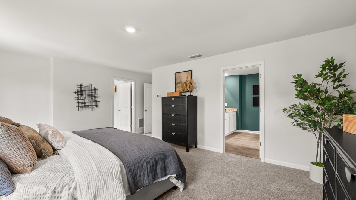 Interior primary bedroom with large windows and accent wall