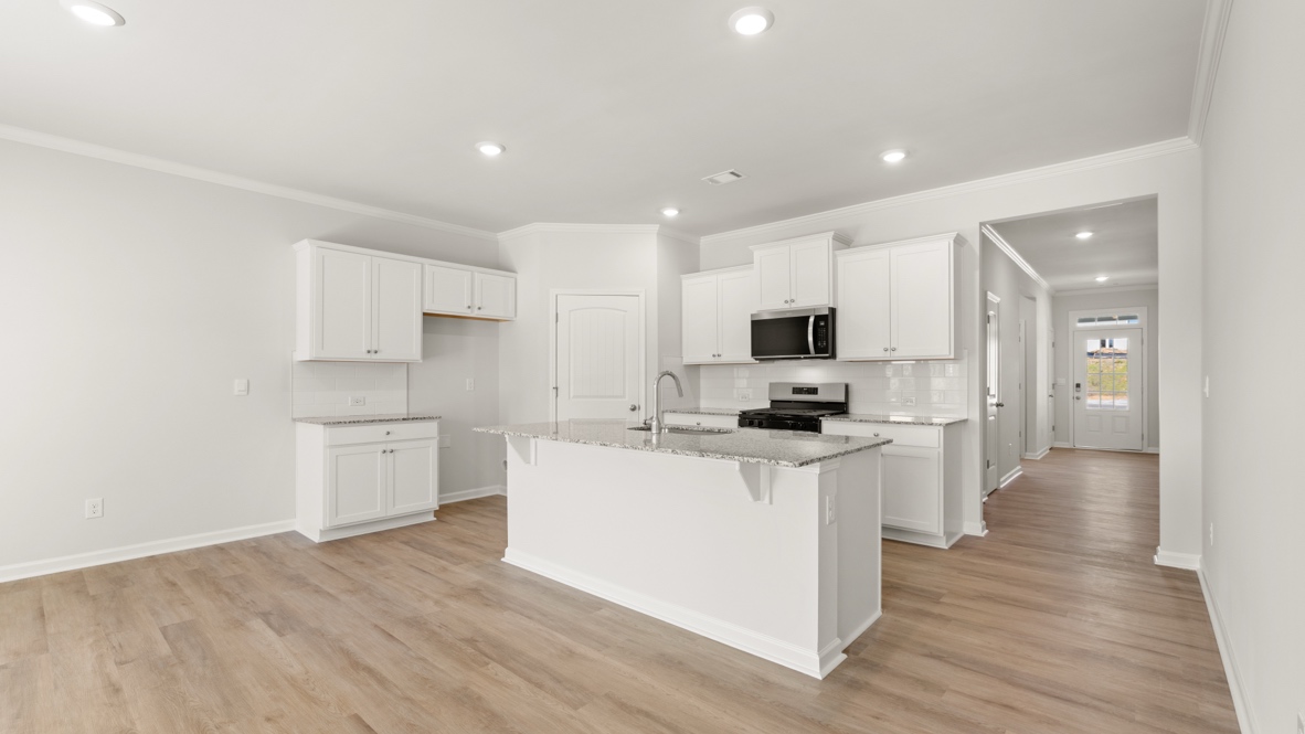 Open kitchen with large island, white cabinets, and stainless steel appliances