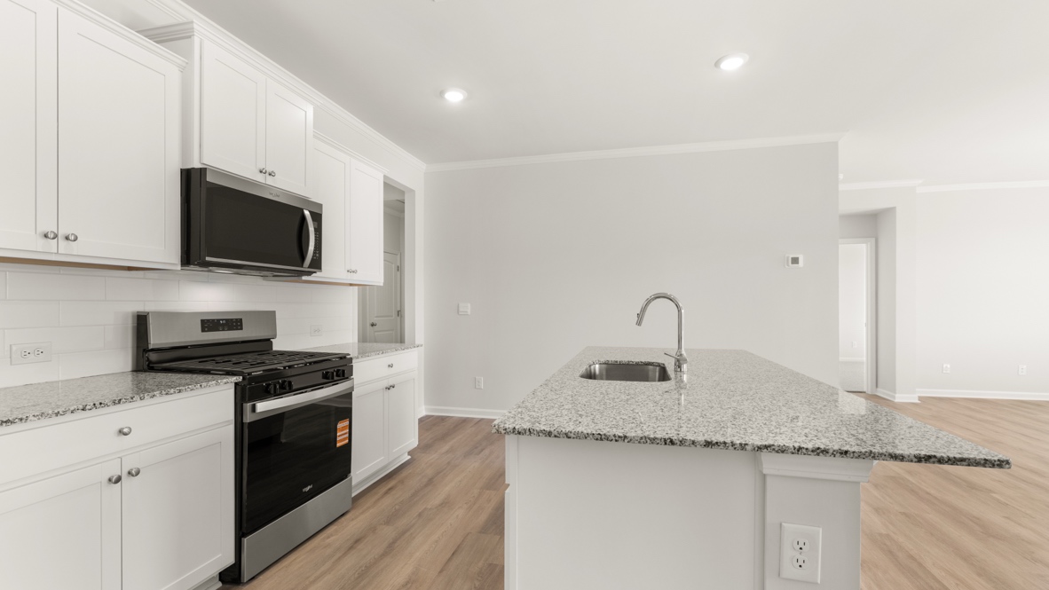 Pantry with wire shelving next to kitchen cabinets and stove.