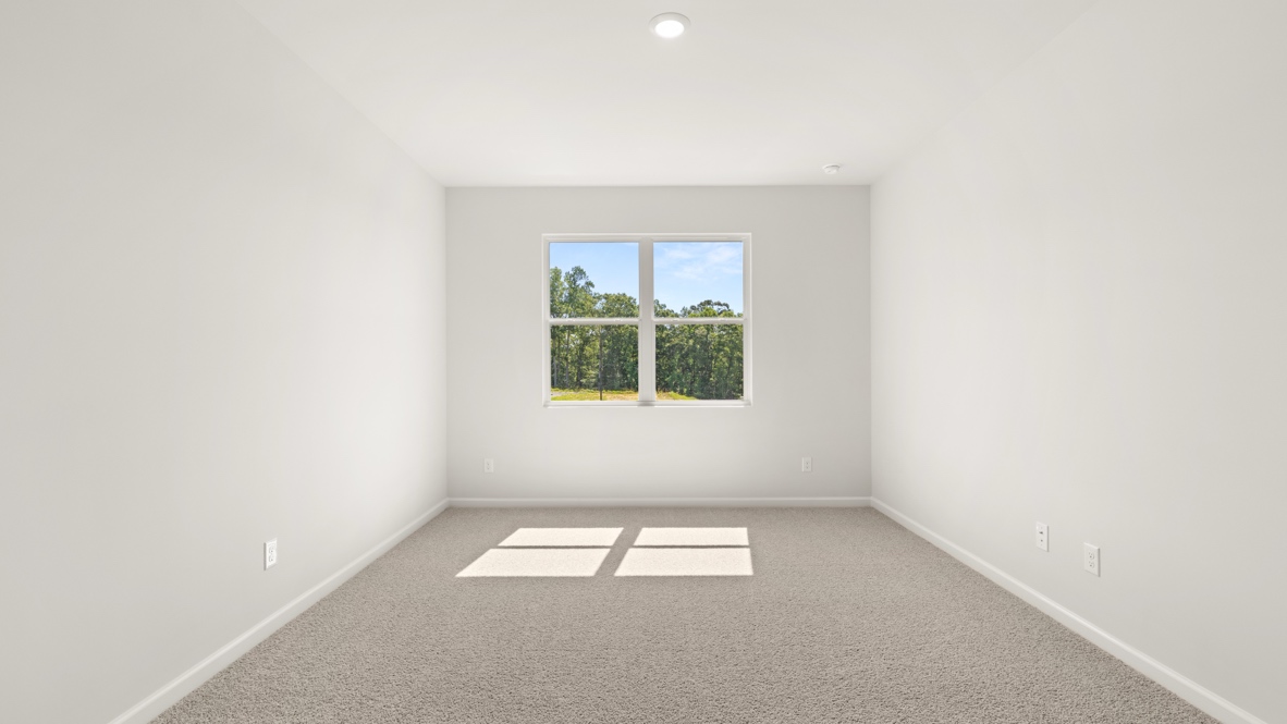 Bedroom with carpet flooring and large window with outdoor view.