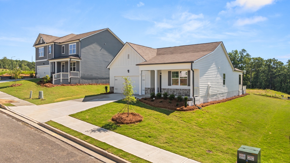Single-story house with front porch, two-car garage, driveway, and green lawn.