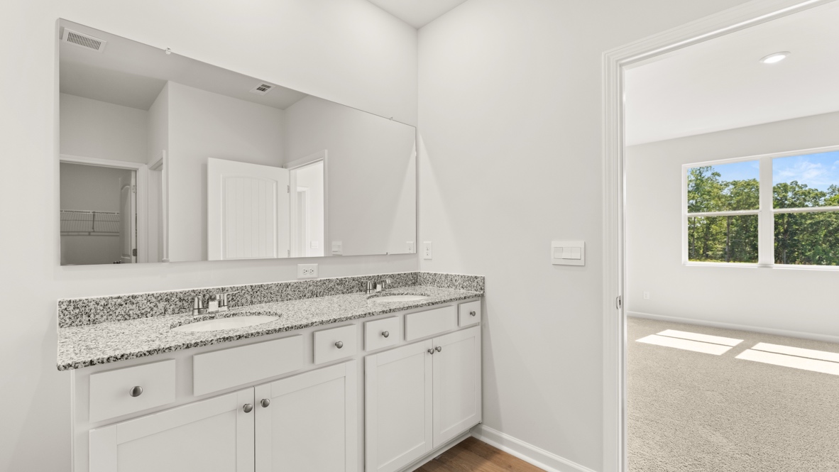 Bathroom with double sink vanity, bathtub, and glass shower.