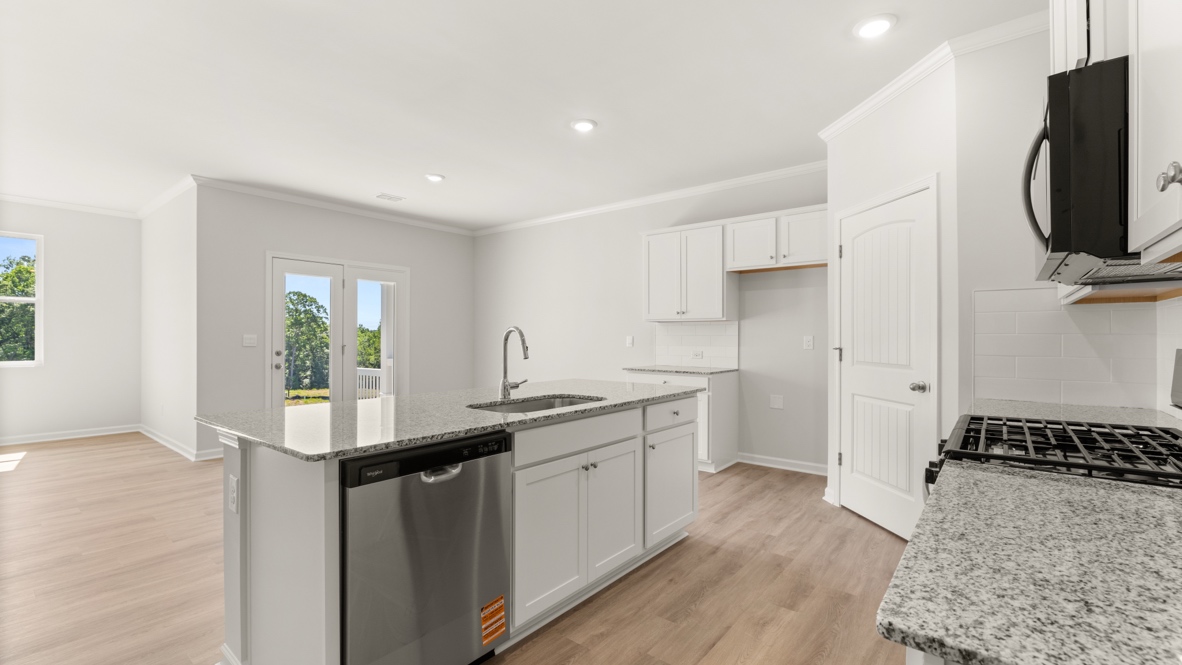 Kitchen with island, sink, dishwasher, and white cabinets.